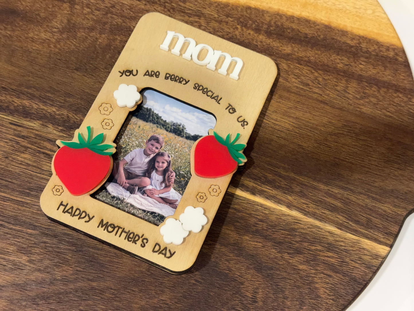 Personalized photo frame with 'mom' and 'Happy Mother's Day' text on a wooden surface