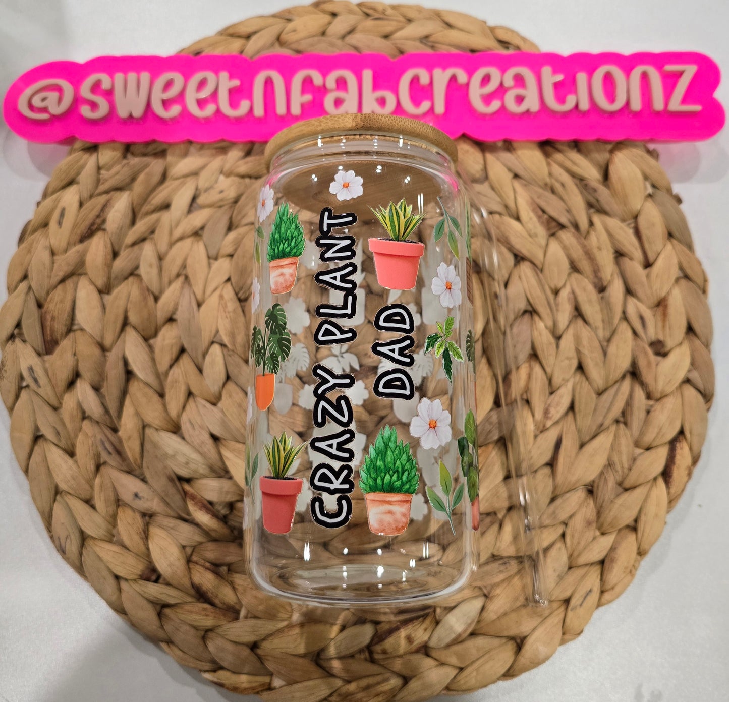 Clear tumbler with plant designs and text on a woven mat, branded with 'sweetnfabcreationz'.