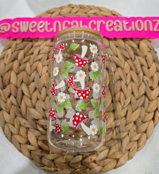 Clear glass jar with mushroom and flower pattern on a woven mat