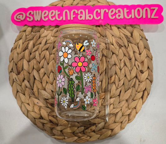 Decorative tumbler with floral designs on a woven mat, branded with 'sweetnfabcreationz'.