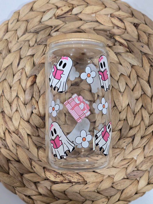 A clear glass cup with a bamboo lid and decorative ghost designs, including depictions of ghosts reading a book