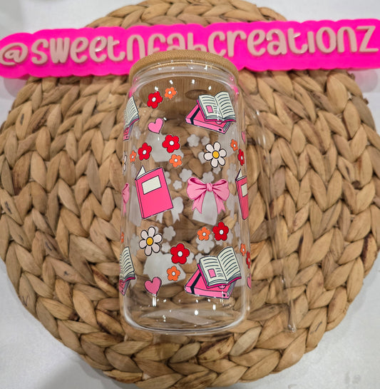 Clear tumbler with colorful designs on a woven surface with 'sweetnahcreationz' branding.