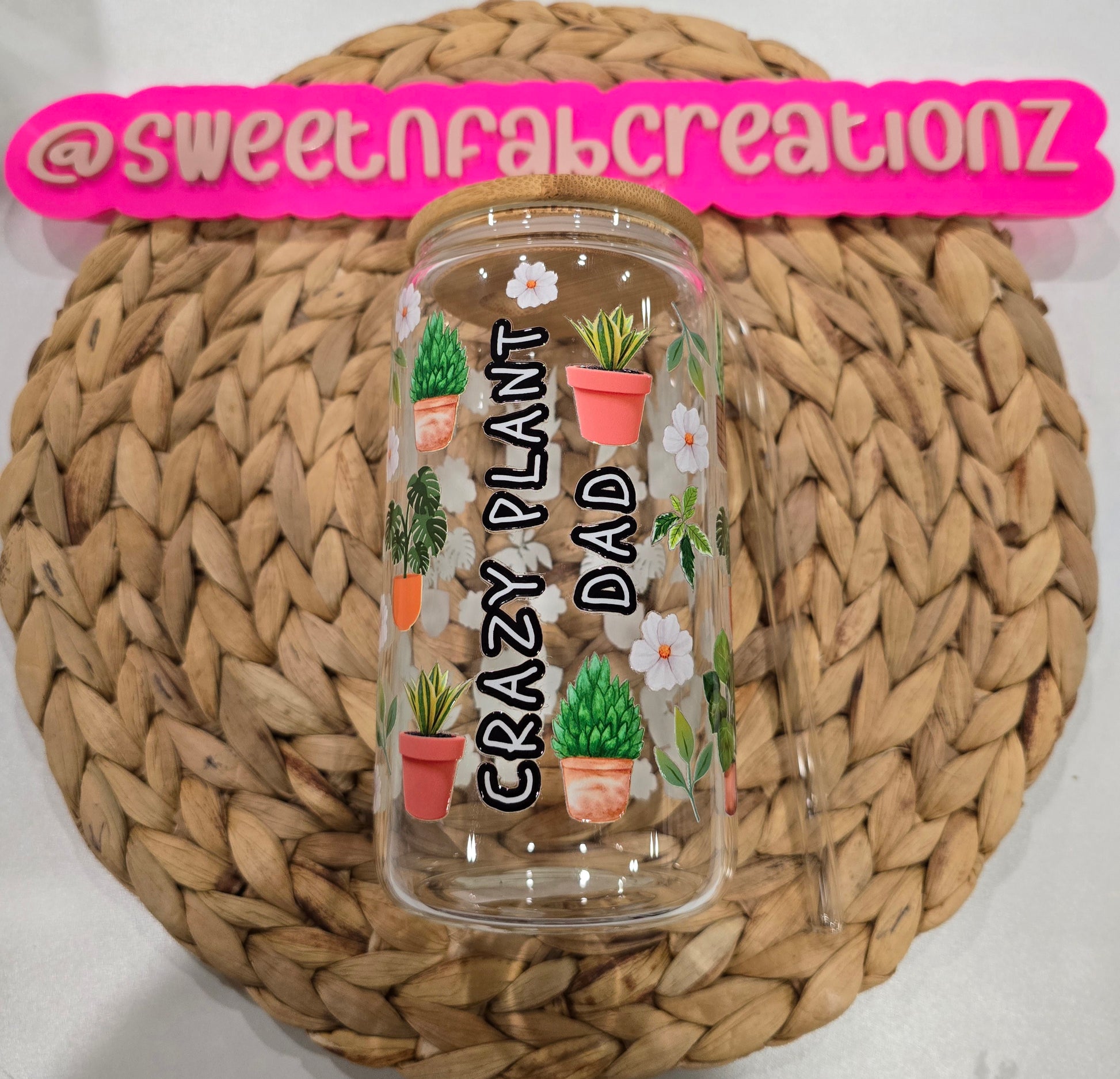 Clear tumbler with plant designs and text on a woven mat, branded with 'sweetnfabcreationz'.