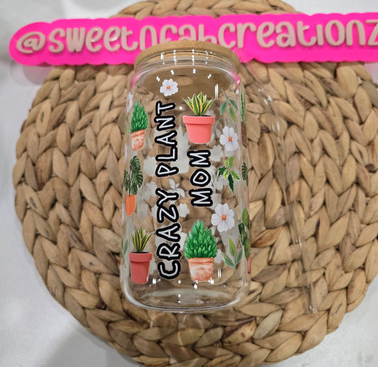 Clear tumbler with plant-themed design and text on a woven surface
